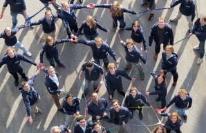 Gruppe von Wissenschaftlern hält sich gegenseitig an den Händen, von oben fotografiert