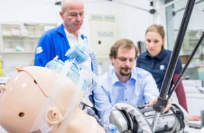 Kai Bremer und Dr. Stefanie Beck blicken Dr. Christoph Doehn über die Schulter. Dieser arbeitet an dem Aufbau für den Maskentest