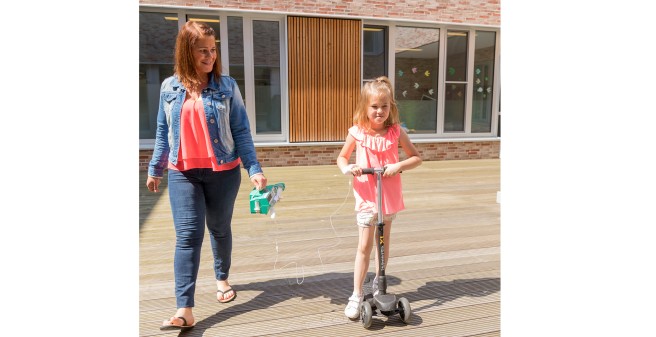 Amelie Schult auf dem Roller, mit Mutter, während der Infusion