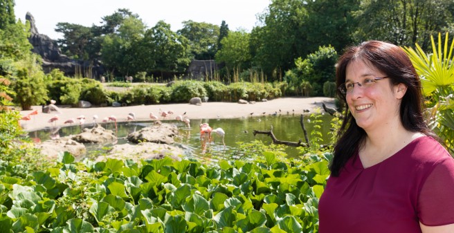 Prof. Karin Oechsle lächend vor den Flamingos