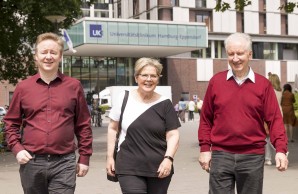 Peter Seifert mit Frau und Sohn schreiben selbstbewusst auf die Kamera zu, im Hintergrund der Haupteingang des UKE. Ein Sommertag