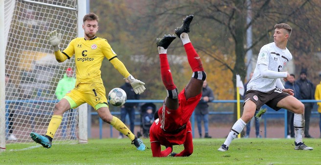 Ein HSV U19 spieler steht nach einem Schuss auf das Tor aus dem Schwung heraus fast auf dem Kopf