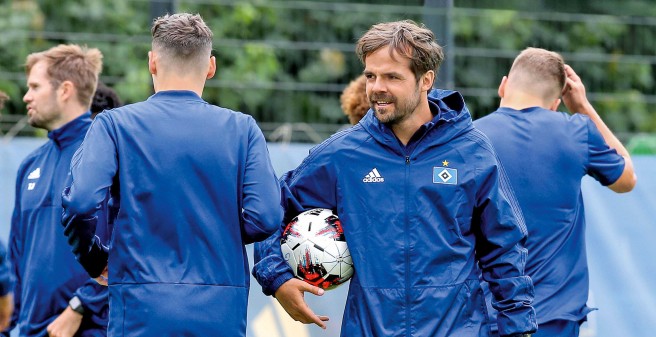 Petrowsky im Kreis seiner Spieler, alle in blauen Trikots. Er schaut zufrieden in die Runde