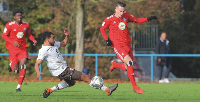 Zwei Spieler aus der U19 des HSV im rasanten Kampf um den Ball. Einer rennt mit dem Ball am Fuß, der andere versucht reinzugrätschen