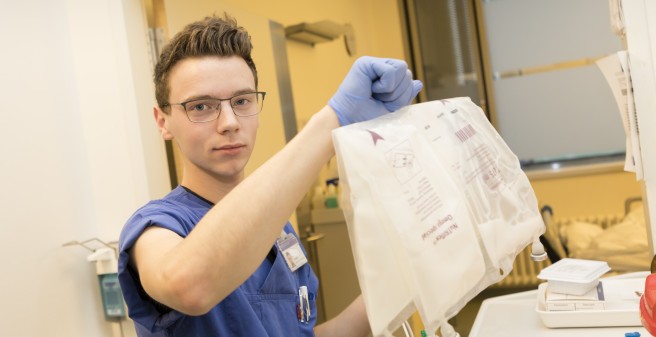 Lukas Gustke mit einem Behältnis in der Hand