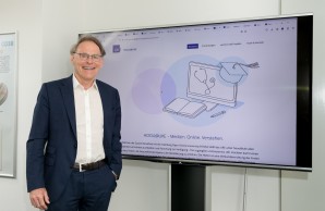 Prof. Dr. Dr. Andreas Guse, Prodekan für Lehre des UKE, vor einem Screen mit der neuen Landingpage hoou@uke