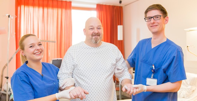 stationärer Patient mit Pflegekräften im Patientenzimmer